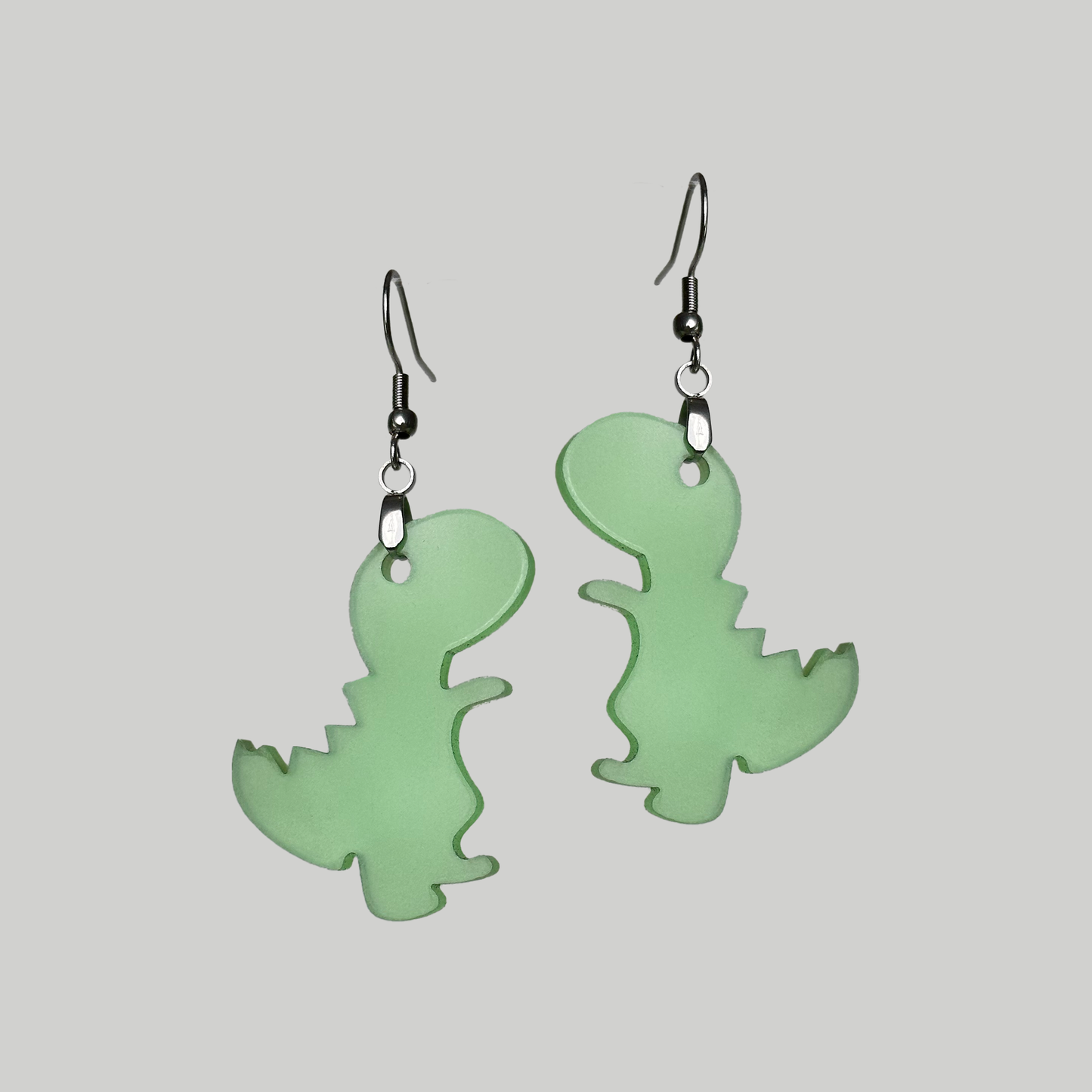 Glow in the dark earrings shaped like dinosaurs, adding a unique and playful element to your style, especially in low-light settings.